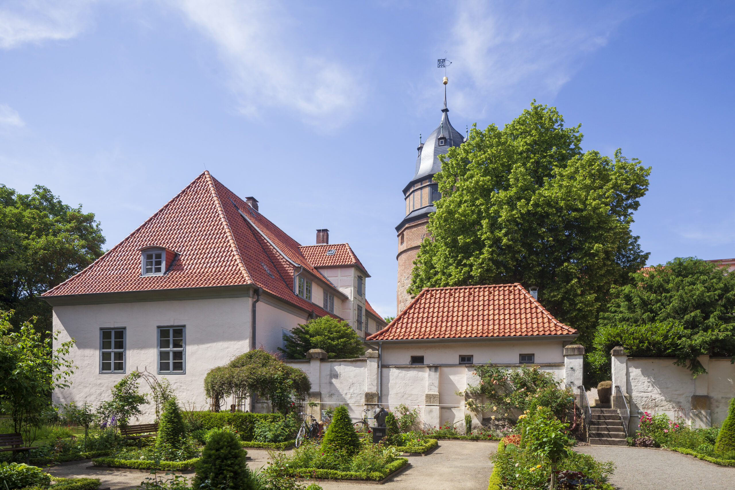 Das Bild zeigt das Diepholzer Schloss mit dem Rosengarten im Vordergrund