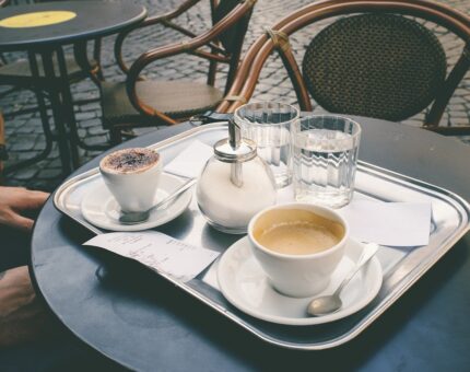 Ein Tablett mit einem Capuccino, einem Kaffee und zwei Gläsern Wasser